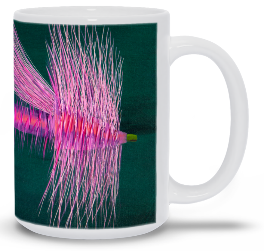 White mug with a pink and green abstract design on a dark background
